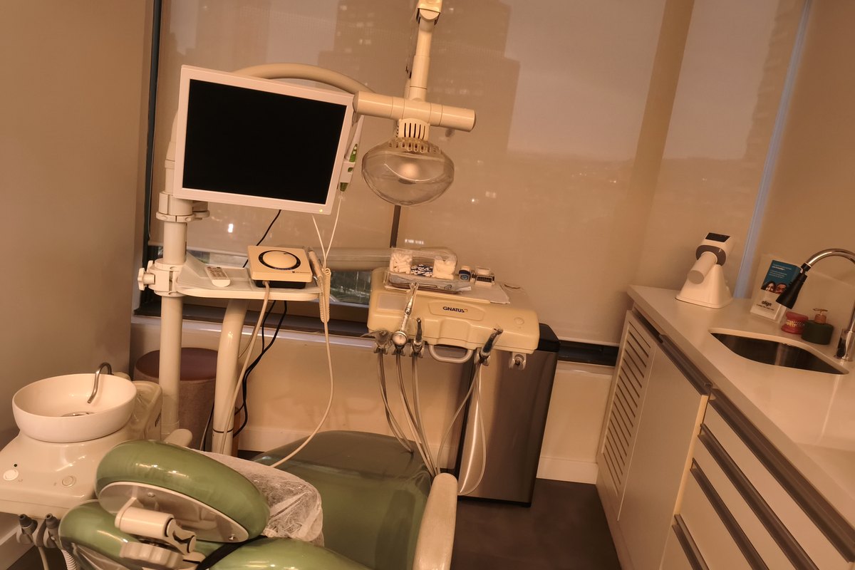 Consultório da Clínica Gusman com equipo, monitor de apoio, cuba e bancada de instrumental