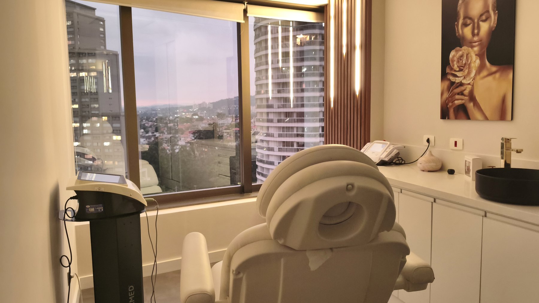 Sala de harmonização orofacial da Clínica Gusman, com maca clínica, bancada de apoio e janela voltada para Alphaville