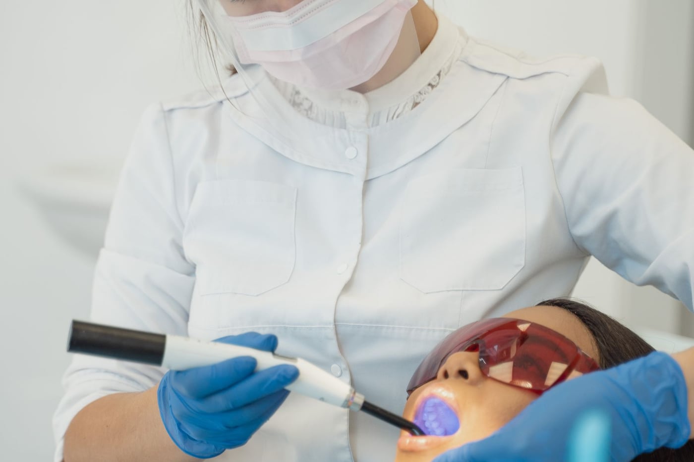 Dentista utilizando fotopolimerizador durante atendimento